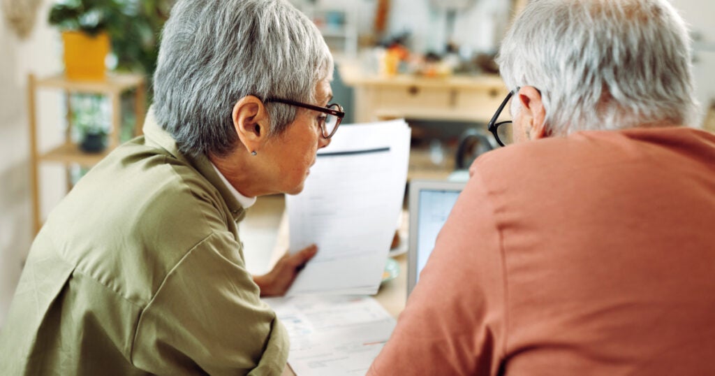 Older couple reviews a stack of bills